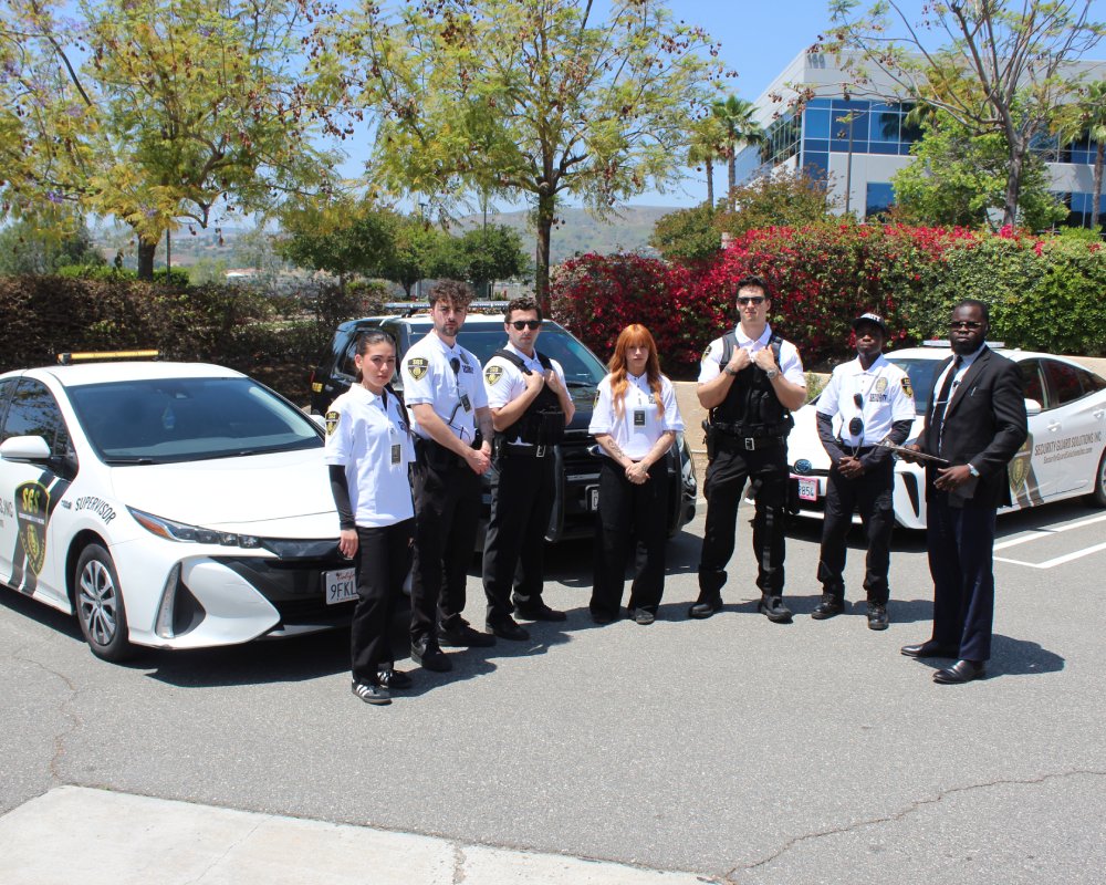 security guards infront of vehicles posing towards camera